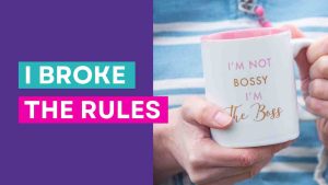 A white mug with the words 'I'm not bossy I'm the boss' close up being held by someone wearing a blue and white striped jumper